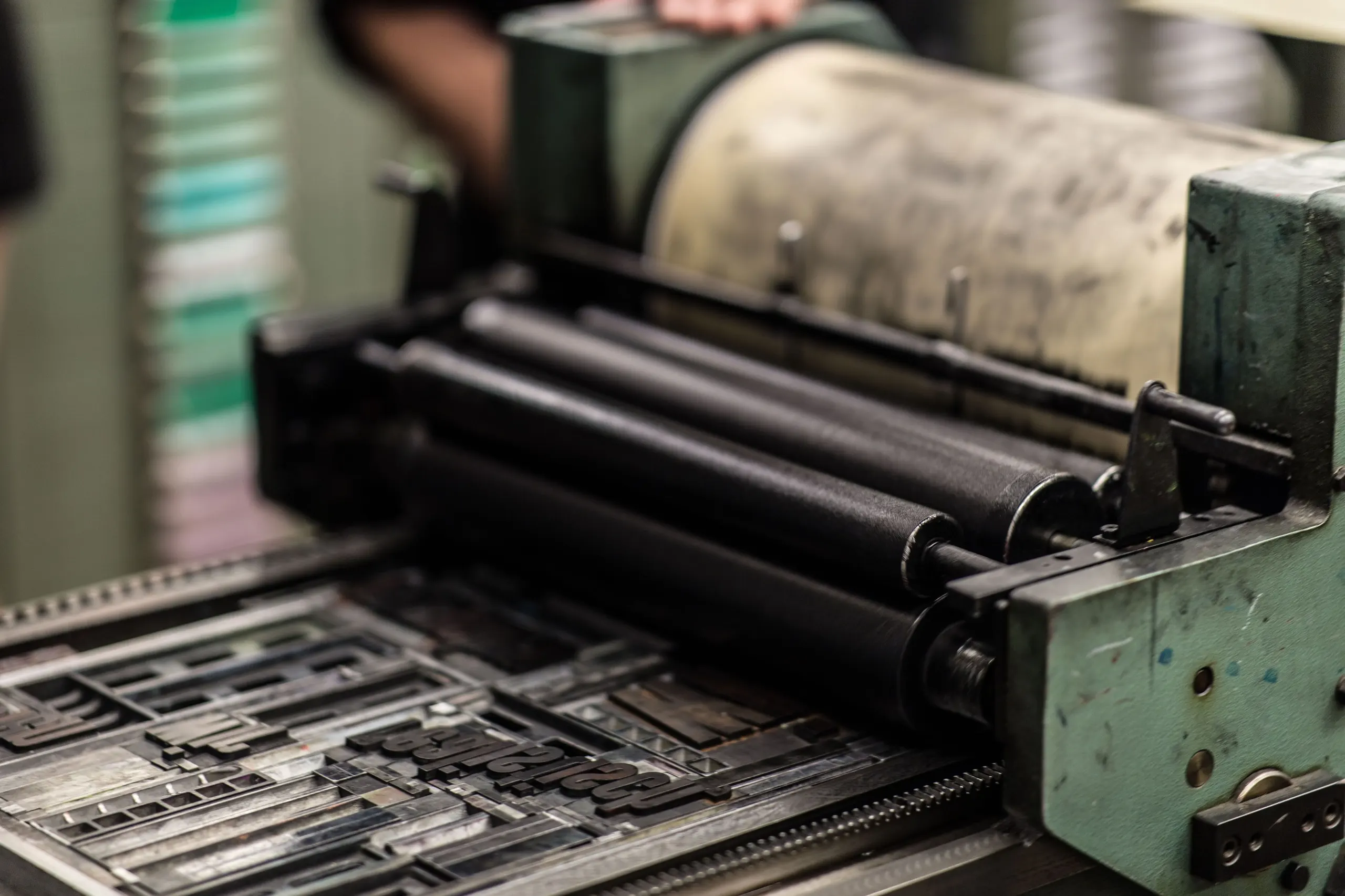 Presse d'imprimerie avec rouleau encreur et composition de caractères en plomb, en atelier.